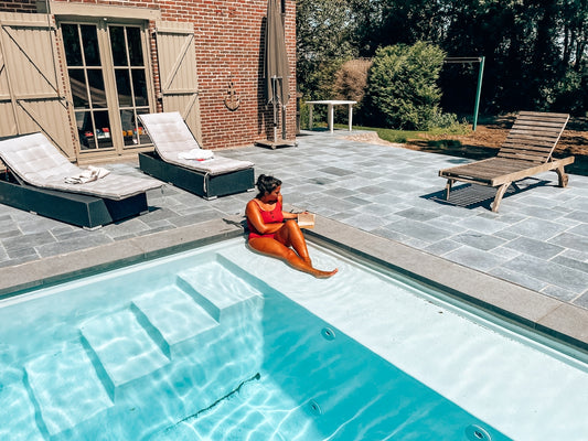 Woman relaxes by the pool on a sunny day.