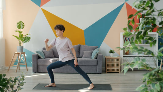 Woman exercising on yoga mat in living room.