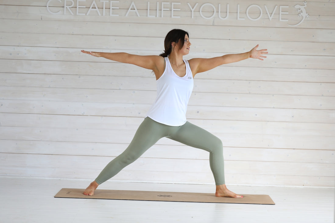 Woman practicing warrior two yoga pose on mat