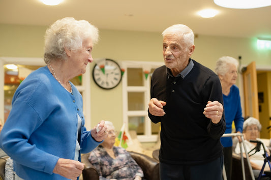 Elderly couple dancing with others in background
