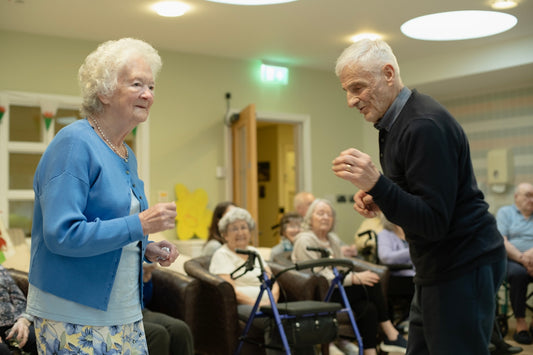 Elderly couple dancing with others watching