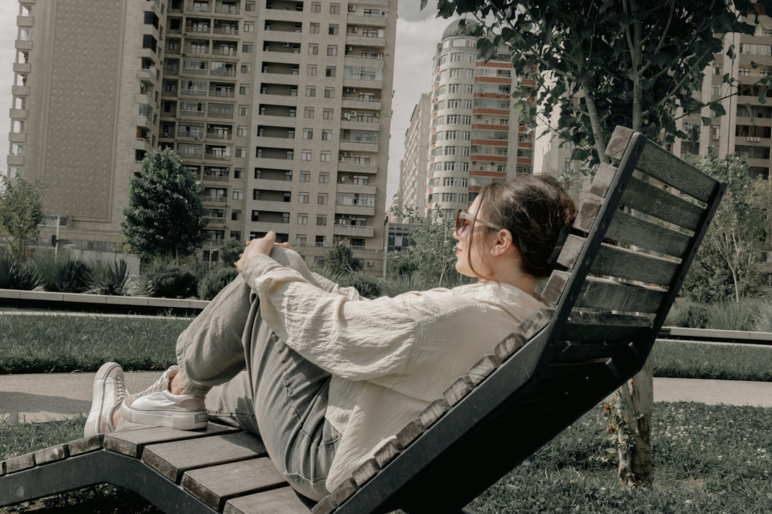 Young woman relaxing on a lounge chair in urban park.