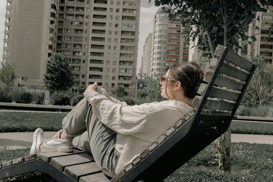 Young woman relaxing on a lounge chair in urban park.