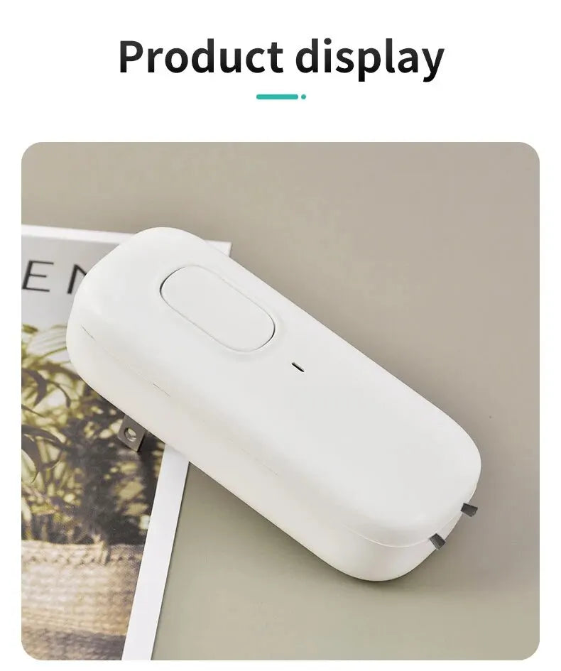 White electronic device on a light gray surface with a magazine underneath