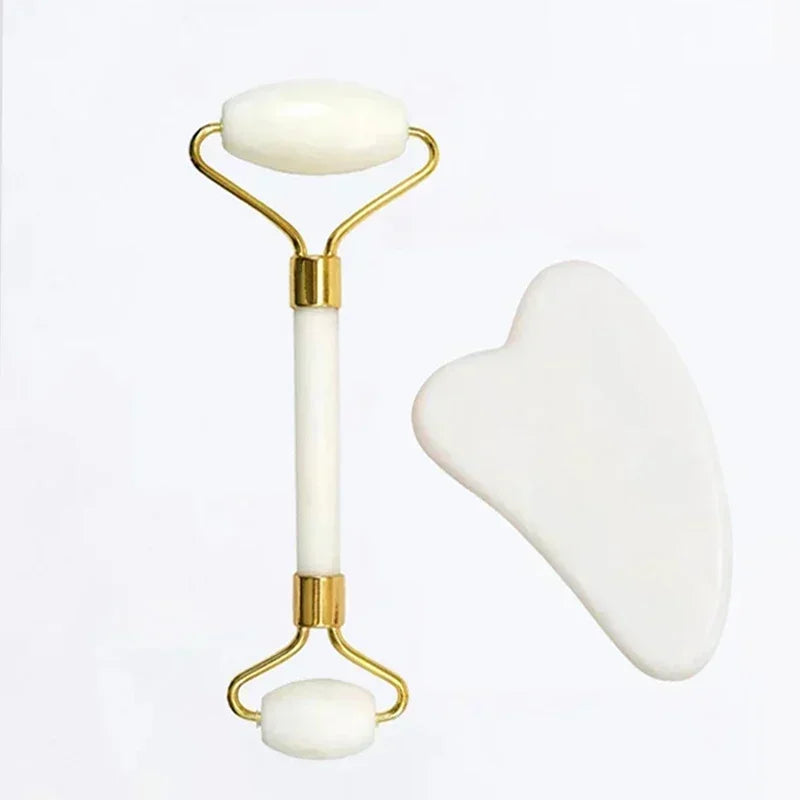 White and gold facial roller and gua sha tool on a white background
