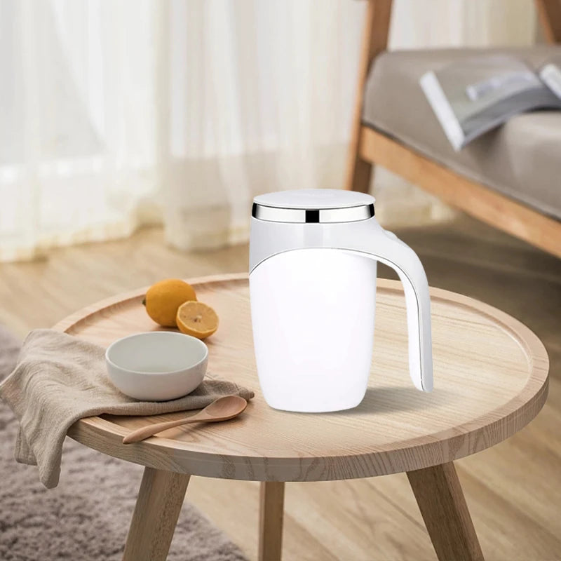 White ceramic pitcher on a wooden table with lemons and a bowl.